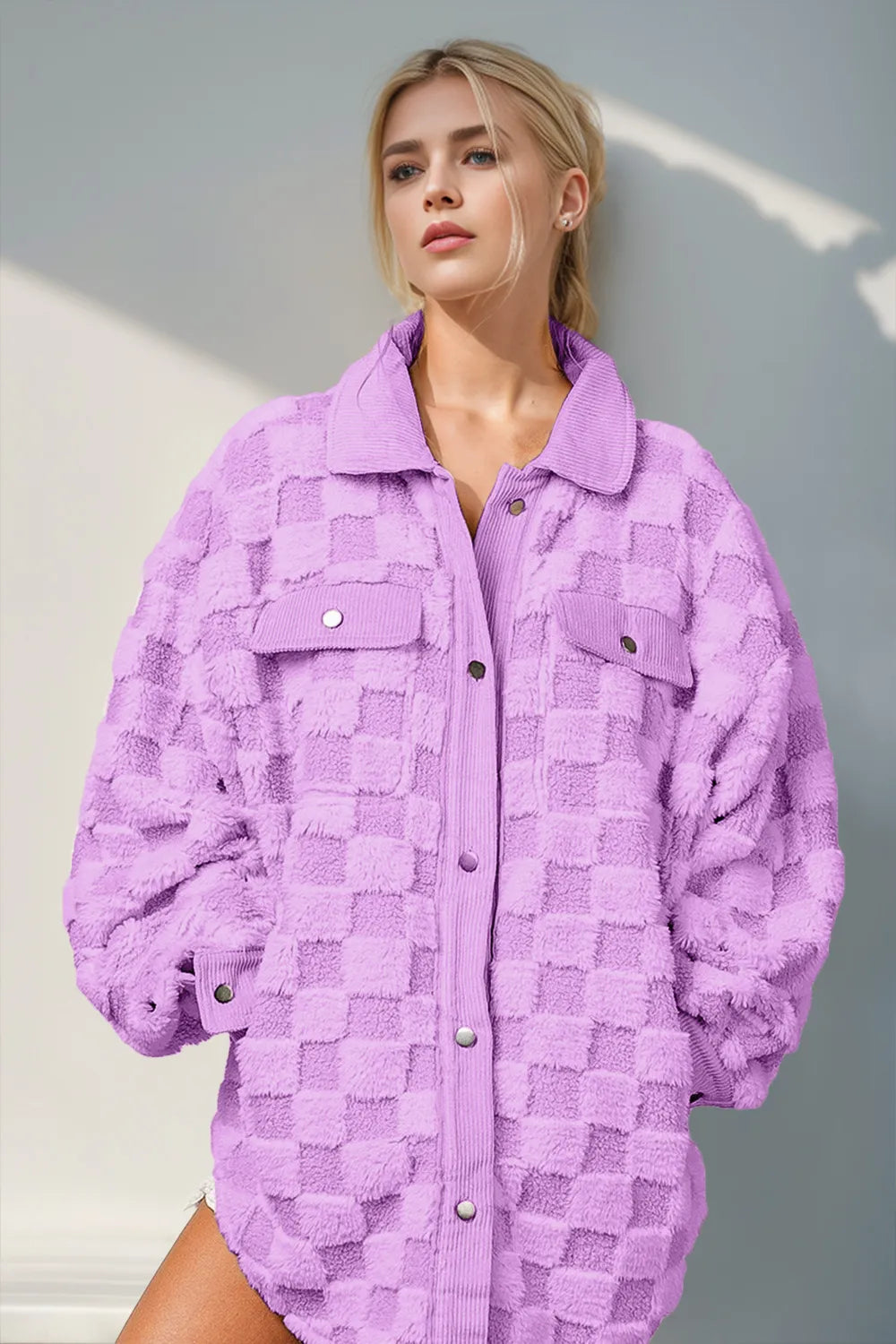 Woman wearing an oversized fuzzy checkered button-up shacket with chest pockets in a purple and cream grid pattern.